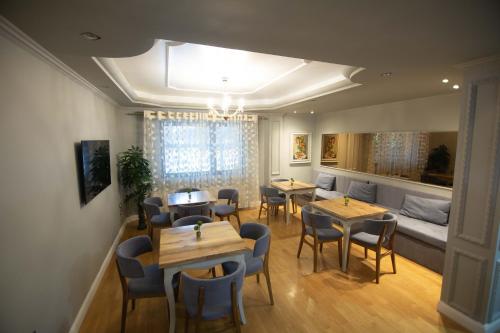 a dining room with tables and chairs and a couch at Vila Mariss in Korçë