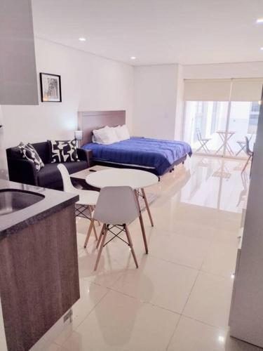a living room with a bed and a table and chairs at Nuevo! Loft hermoso con alberca. Wi-Fi Rapido. in Mexico City