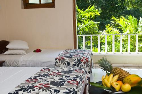 a room with a bed and a bowl of fruit on a table at Hotel Sunflower in Kataragama