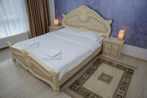 a bedroom with a large white bed with two night stands at Apartament Corso in Turda
