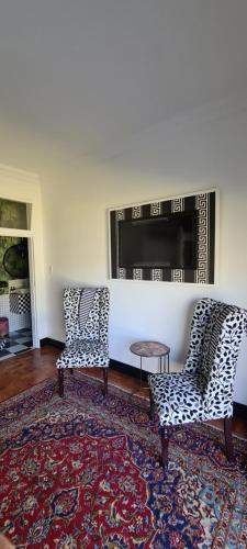 a living room with two chairs and a fireplace at Villa Grande Luxury accommodation in Welkom