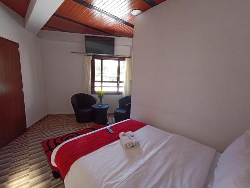 a bedroom with a bed with two shoes on it at Hotel Malaki in San Agustín