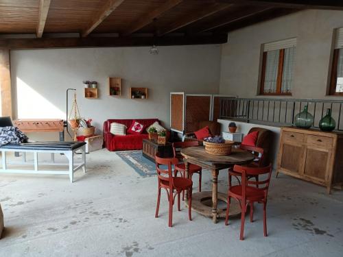 salon ze stołem i czerwonymi krzesłami w obiekcie CASA ABUELA w mieście Palacios de la Valduerna