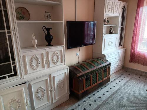 a living room with a tv and a bench in a room at CASA ABUELA in Palacios de la Valduerna