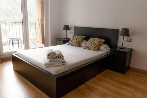 1 dormitorio con 1 cama grande y toallas. en Apartamento moderno El Bosque en Arinsal, en Arinsal