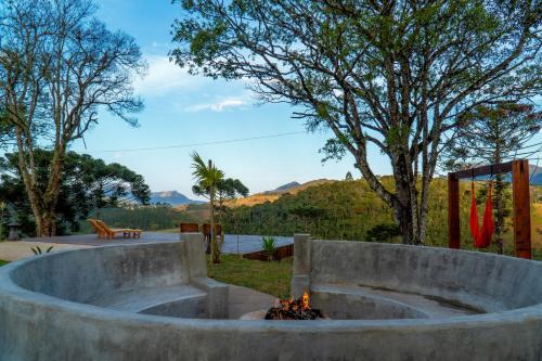 a fire pit in a yard with a view of a lake at Atiaia Jungle River Retreat in Visconde De Maua