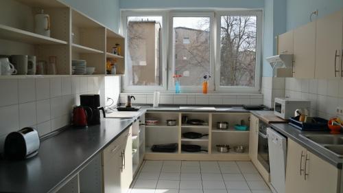 a kitchen with white cabinets and a large window at Hostel Inn-Berlin in Berlin