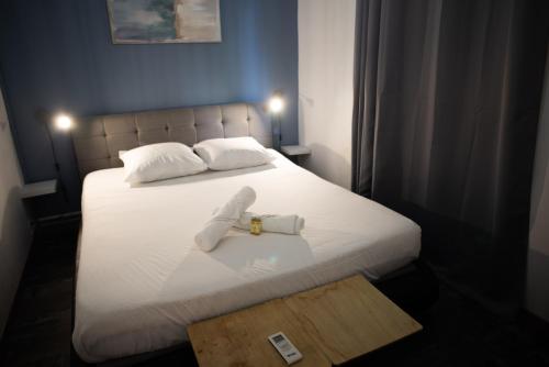 een slaapkamer met een bed met twee handdoeken erop bij Le Bambou T3 Centre ville Sainte Clotilde Rez de jardin in Bois de Nèfles
