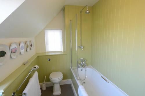 ein Badezimmer mit einer Badewanne, einem WC und einem Waschbecken in der Unterkunft 2 The Dunes, Thorpeness in Thorpeness