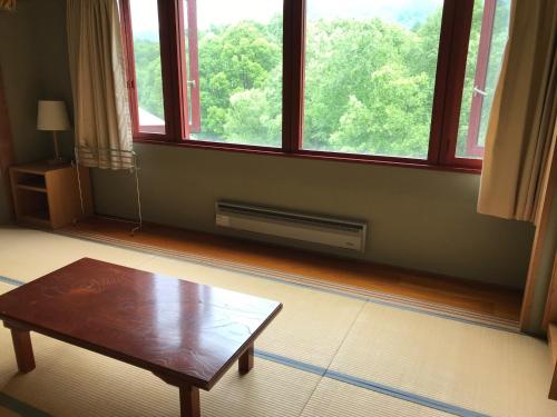 a living room with a table and a large window at Aizu Kogen International Human Resources Center - Vacation STAY 34905v in Minamiaizu