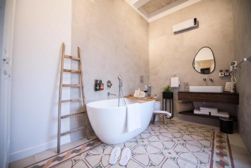 a bathroom with a large white tub and a sink at Casa Maria Tereza in Cospicua