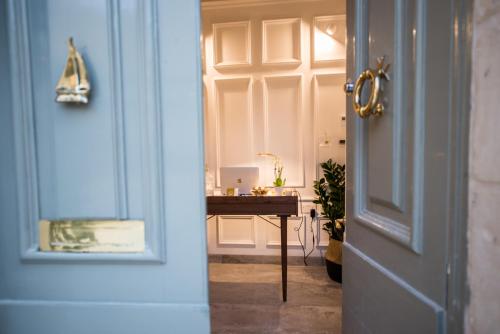 a door leading into a room with a desk with a laptop at Casa Maria Tereza in Cospicua
