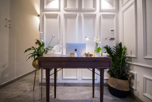 a table with a laptop on it in a room with plants at Casa Maria Tereza in Cospicua