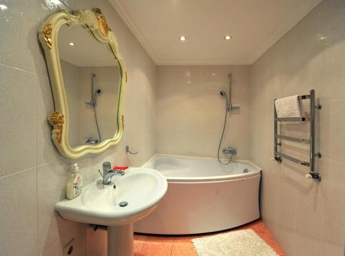 bagno con vasca, lavandino e specchio di Oreanda Hotel a Odessa