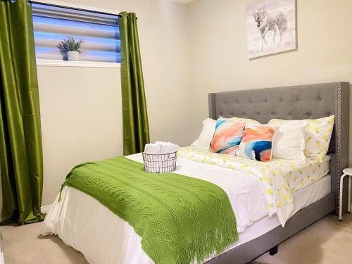 a bedroom with a bed with green curtains at Cozy Newly Built and Cheerful 1-Bedroom Suite in Calgary