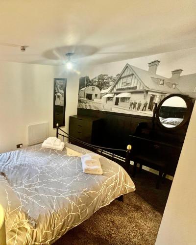 a bedroom with a bed and a picture of a house at The Mail Barn in Lamlash