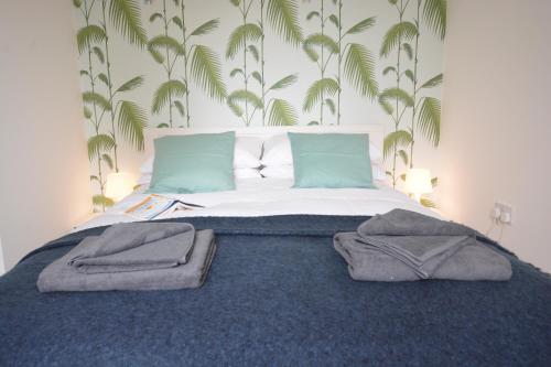 1 dormitorio con 1 cama con toallas en Sweet Pea, Southwold, en Southwold