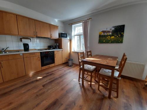 uma cozinha com uma mesa de madeira e um piso de madeira em Pension Kastanienhof em Zeulenroda