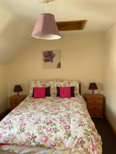 una camera da letto con un grande letto con cuscini rosa di Albion Cottages a Bridlington