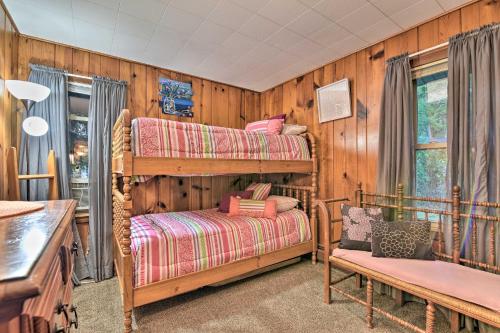 een slaapkamer met 2 stapelbedden en een bank bij Cozy Lakefront Lapeer House with 2 Paddle Boats! in Lapeer