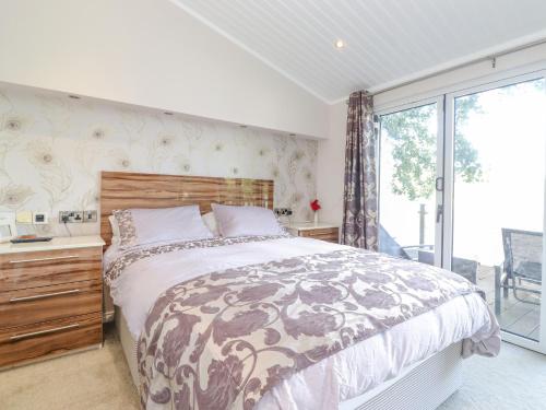 Un dormitorio con una cama grande y una ventana en Lakeside Lodge en Windermere
