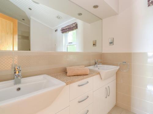 a white bathroom with two sinks and a mirror at Lakeside Lodge in Windermere