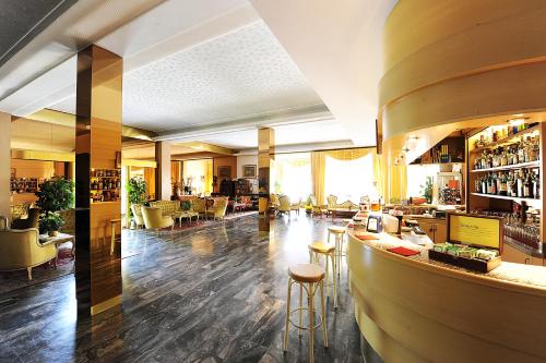 a lobby of a hotel with a bar and stools at Hotel Terme Patria in Abano Terme