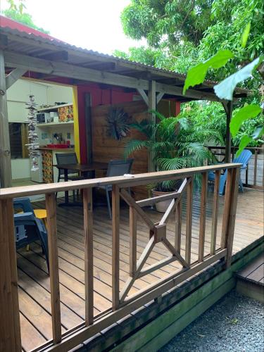 a wooden deck with chairs and a table at Les Manguiers in Deshaies