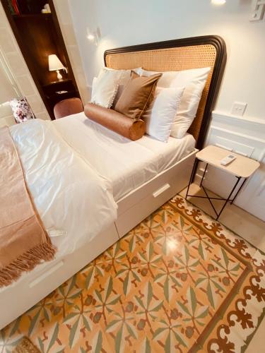 a bed with white sheets and pillows in a room at Casa Maria Tereza in Cospicua