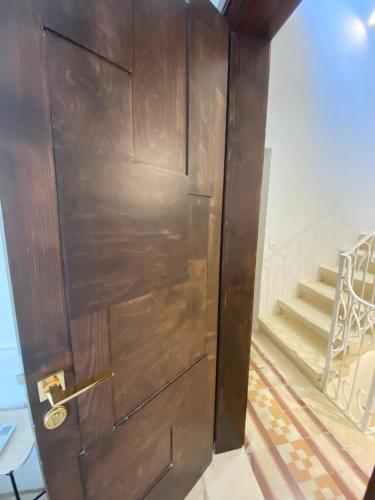 a wooden door in a room with a staircase at Casa Maria Tereza in Cospicua
