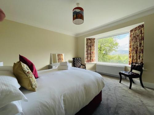 a bedroom with a large bed and a large window at Three Peaks in Braithwaite