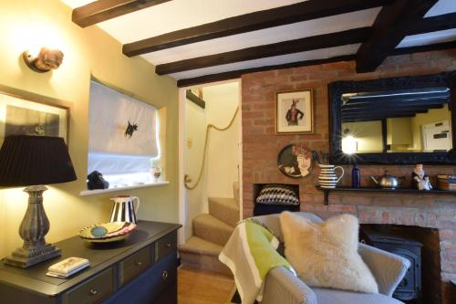 a living room with a fireplace and a couch at Cherry Tree Cottage, Woodbridge in Woodbridge