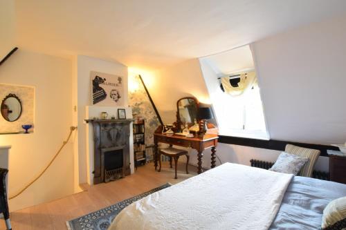 a bedroom with a bed and a desk and a mirror at Cherry Tree Cottage, Woodbridge in Woodbridge