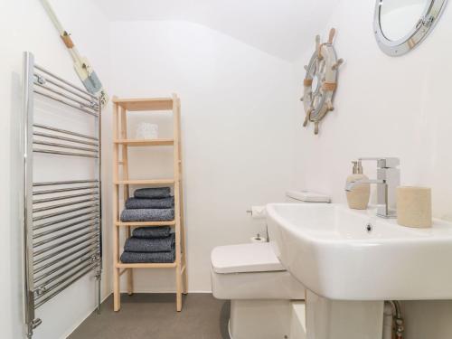 a white bathroom with a sink and a toilet at Bridges Cottage in Torquay