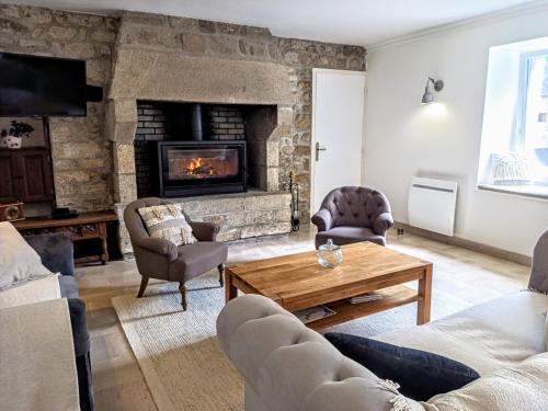 a living room with a couch and a fireplace at La Ferme de Penanguer in Loctudy