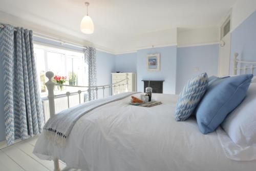a bedroom with a large bed with blue walls at Somewhere Only We Know, Aldeburgh in Aldeburgh