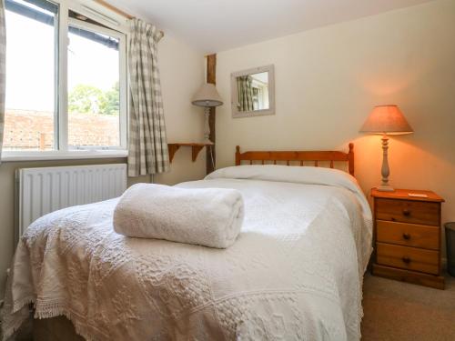 a bedroom with a white bed and a window at Byre Cottage 5 in Pulborough