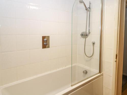een badkamer met een douche en een glazen deur bij Byre Cottage 5 in Pulborough