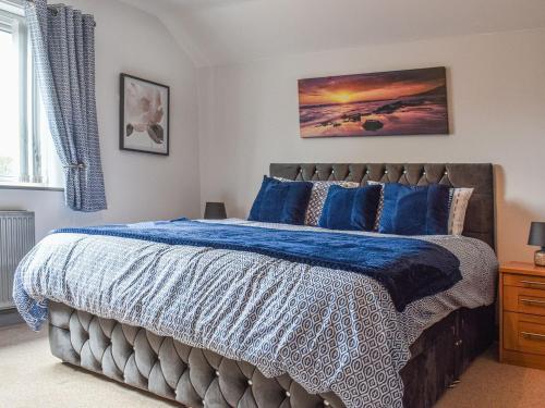 a bedroom with a bed with a blue comforter at Brookside House in Pickering