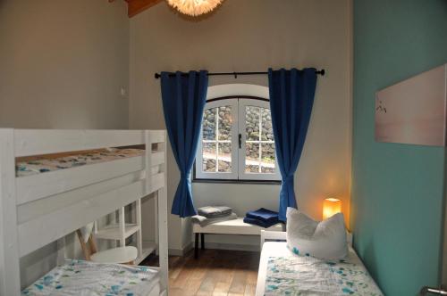 a bedroom with two bunk beds and a window at Azorenhaus am Atlantik - Family House in Urzelina