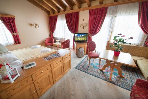 a bedroom with a bed and a desk and a tv at Hotel Valtellina in Livigno