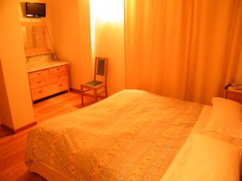 a bedroom with a bed and a dresser and a mirror at Fattoria Meneguto Agriturismo Degasper Giorgio in Cortina dʼAmpezzo