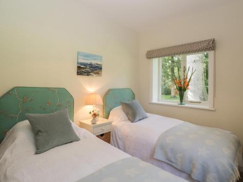 a bedroom with two beds and a window at The Roost in Cheriton