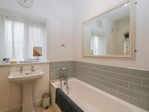 a bathroom with a tub and a sink and a mirror at The Roost in Cheriton