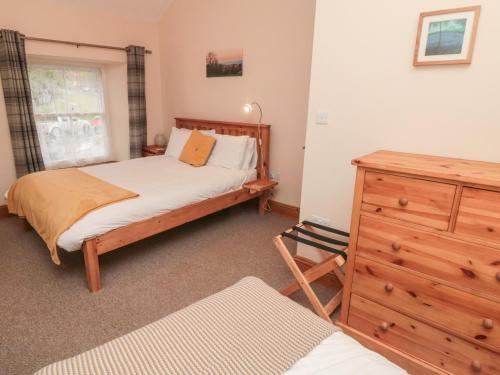 1 dormitorio con cama y tocador de madera en Crumble's Cottage, en York