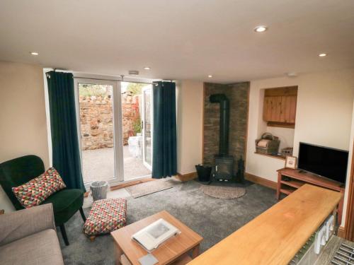 a living room with a couch and a tv at Crumble's Hideaway in York