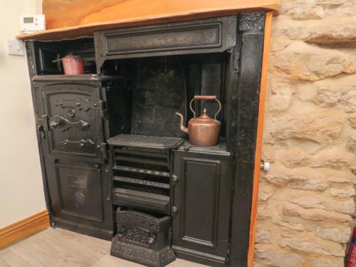 an old black stove with a tea kettle in it at Crumble's Hideaway in York