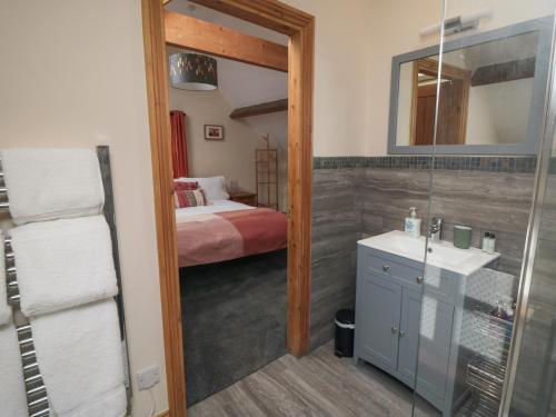 ein Bad mit einem Bett, einem Waschbecken und einem Spiegel in der Unterkunft Crumble's Hideaway in York