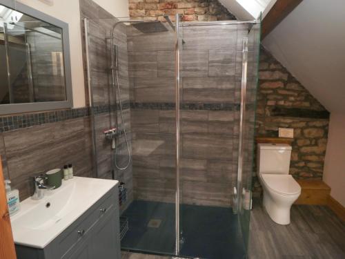 a bathroom with a shower with a toilet and a sink at Crumble's Hideaway in York