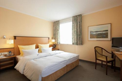 Cette chambre comprend un lit, un bureau et une télévision. dans l'établissement Hotel Gasthof Vogelsang, à Zellingen